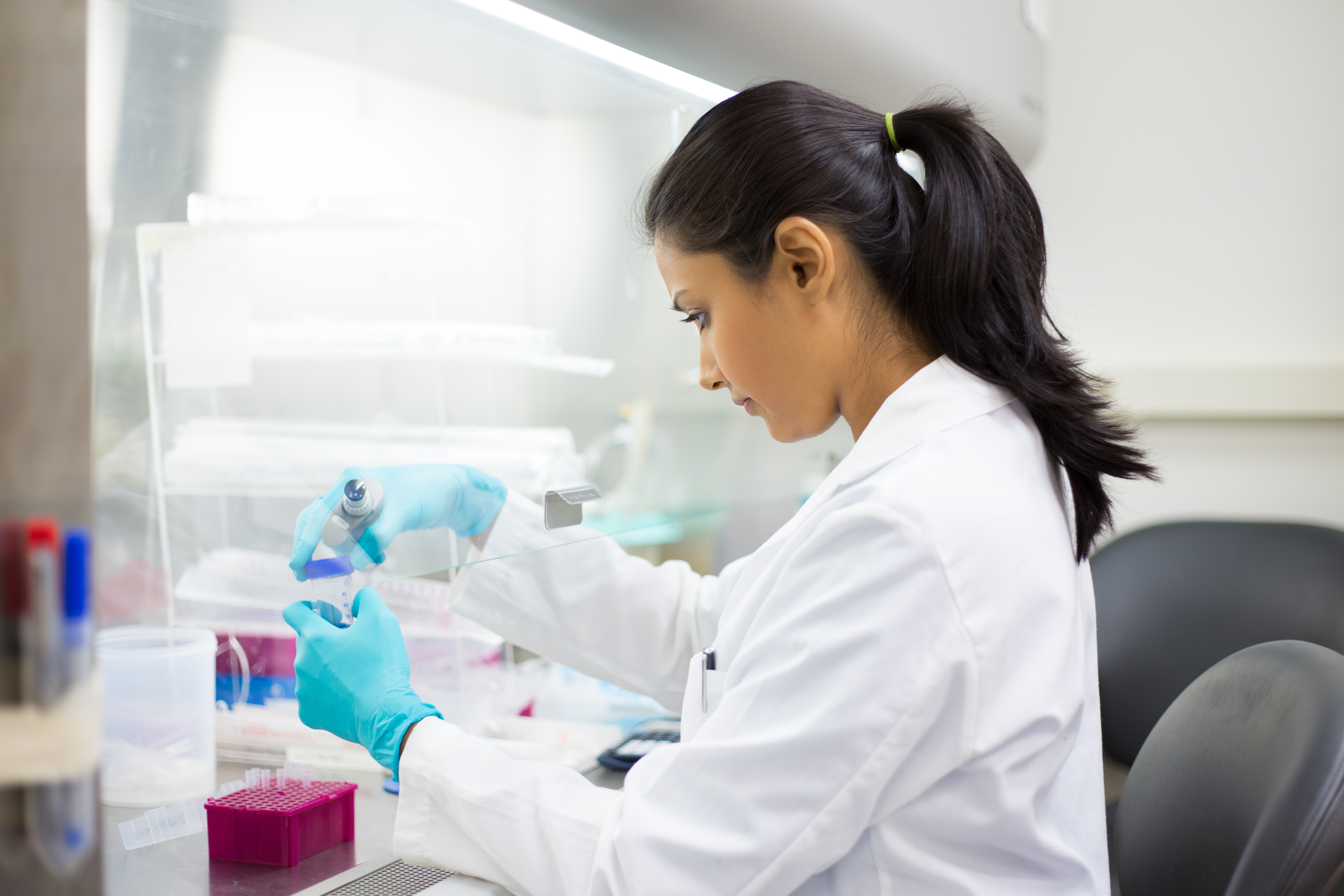 A researcher in a lab conducting an in vitro diagnostic (test tube) procedure.