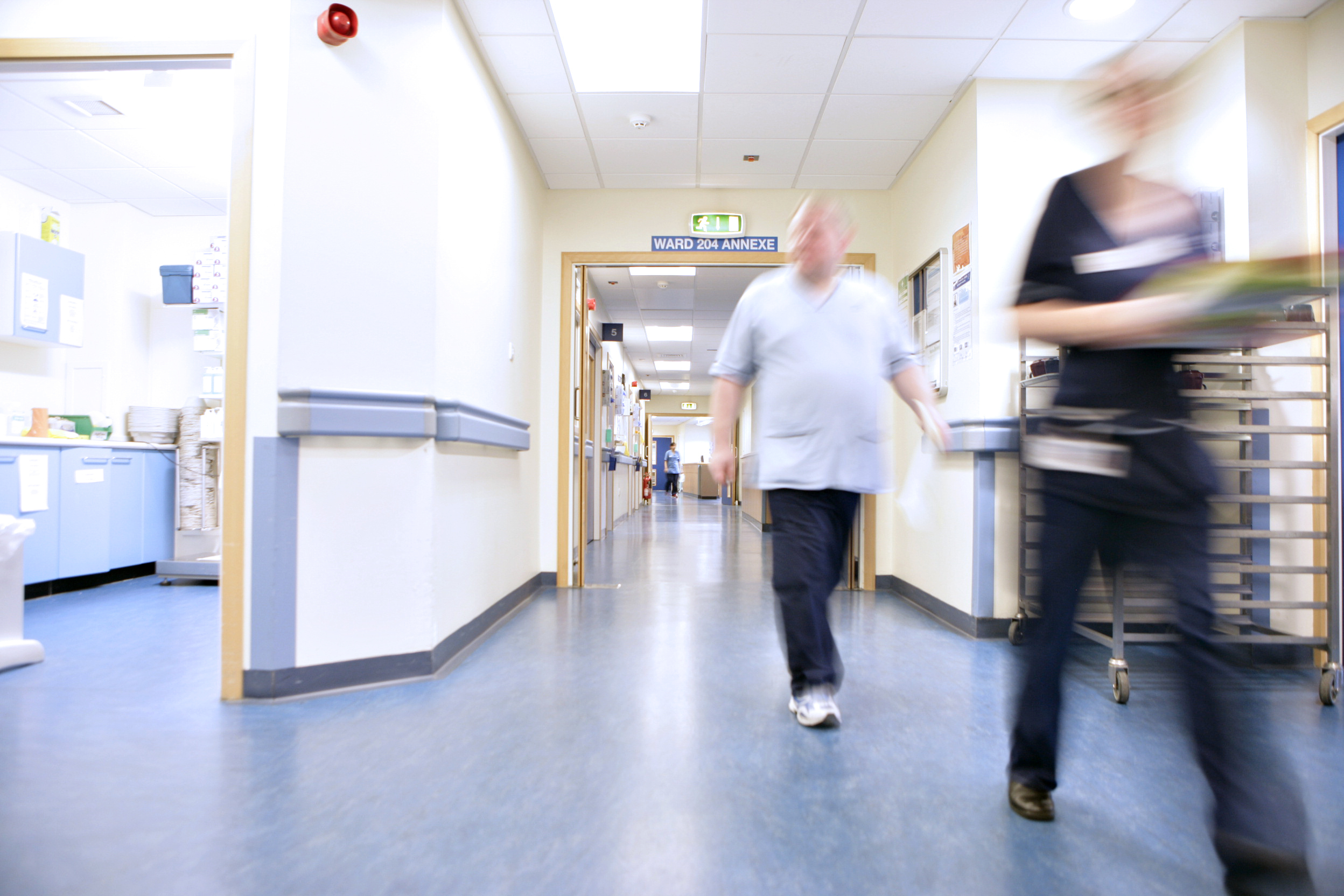 Interior shot of an NHS Scotland healthcare facility, with staff walking towards the camera.