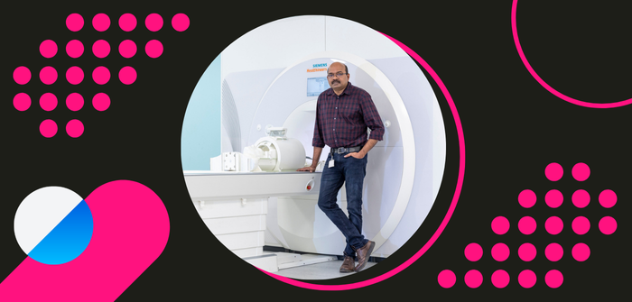 MRS CoilTech member of staff standing next to an MRI machine, inside a pink, blue and white 'case studies' framing device.