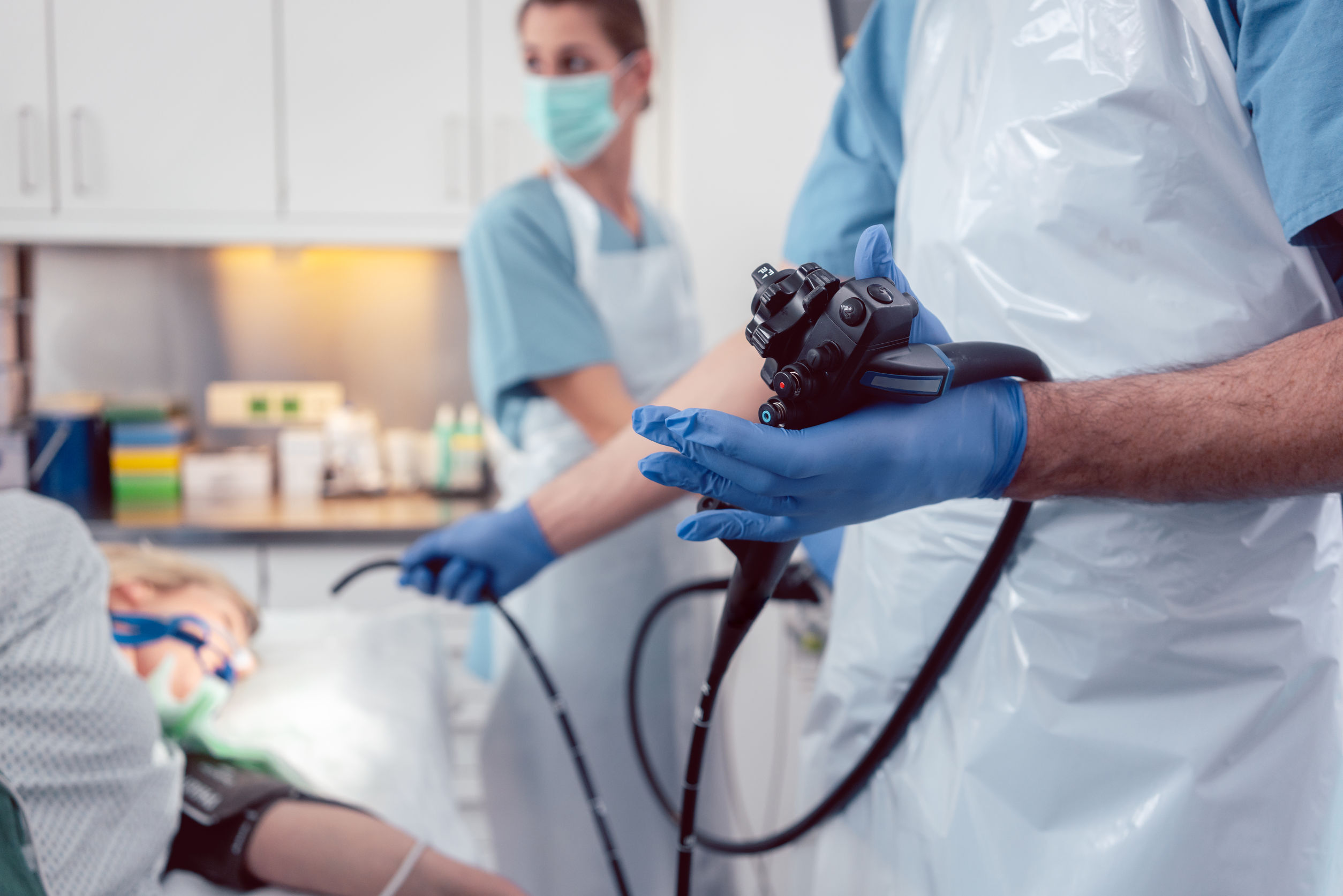 A medical professional in a surgical setting holding a medical device.