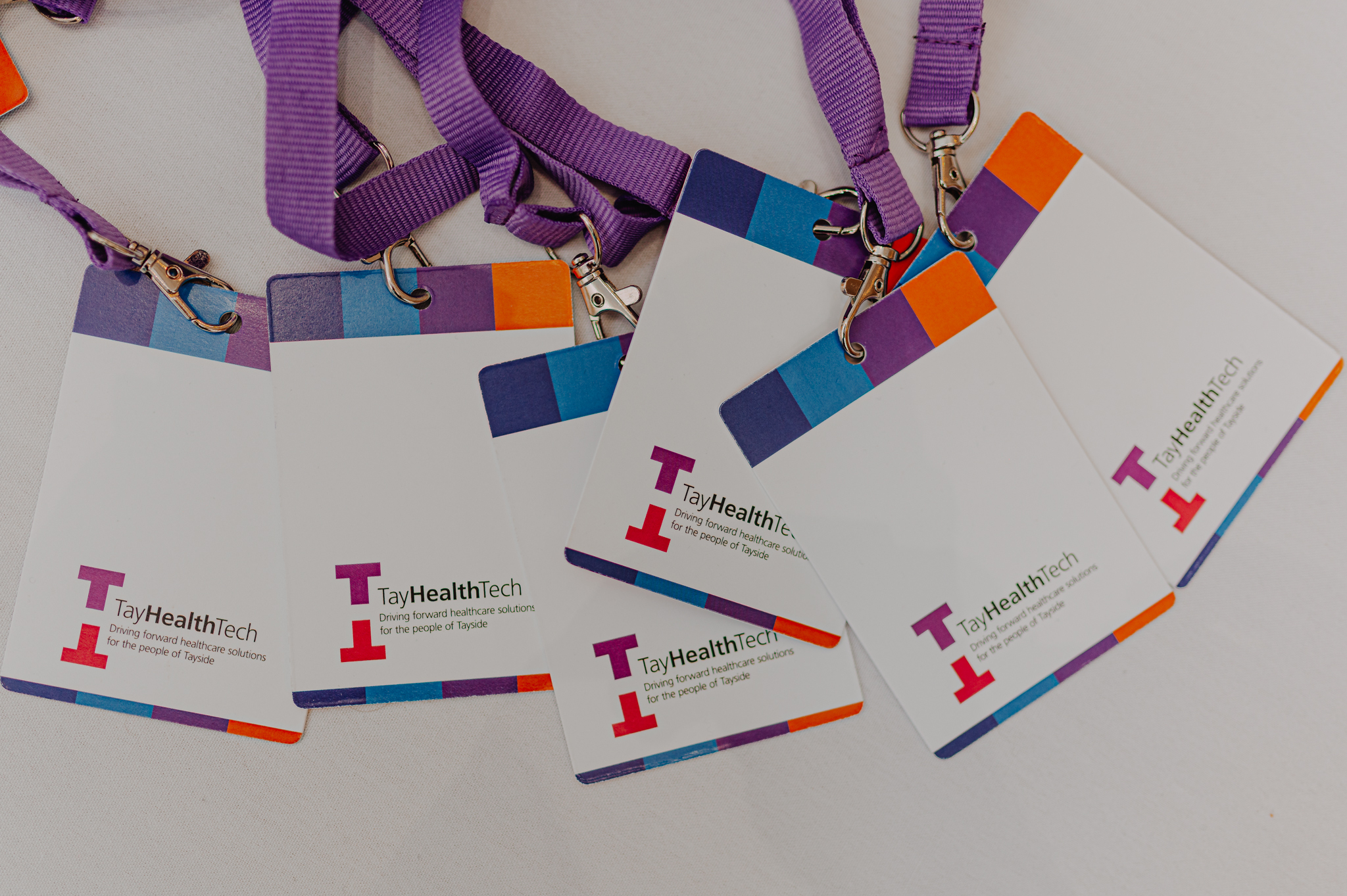 Tay Health Tech lanyards arranged on a table.